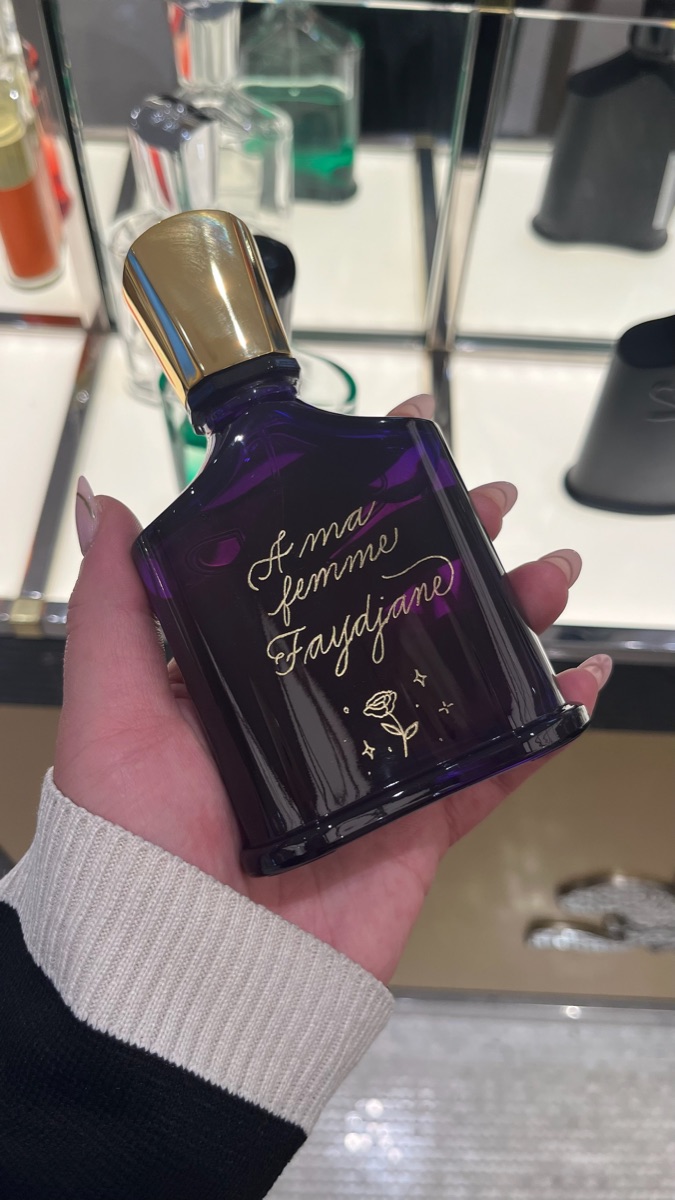 Flacon Creed au verre violet foncé, dédicace « À ma femme Faydjane » gravée à la main en doré avec une petite rose