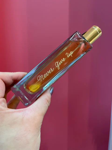 Flacon de parfum Adopt gravé du message Never Give Up sur sa longueur