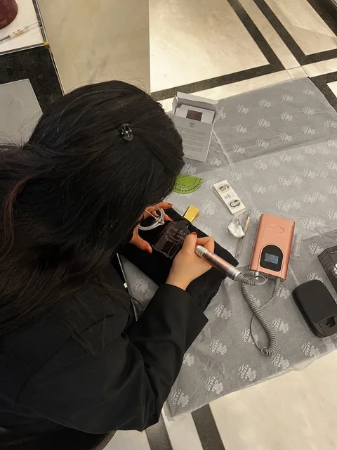 Vue du dessus de Cathy travaillant sur un flacon à son poste de gravure en boutique
