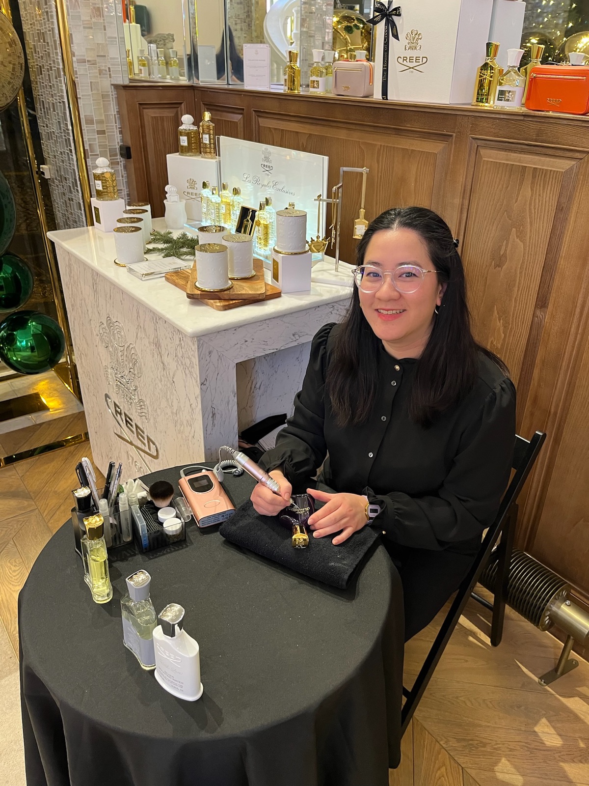 Cathy grave un flacon pour un client, en animation de marque en boutique
