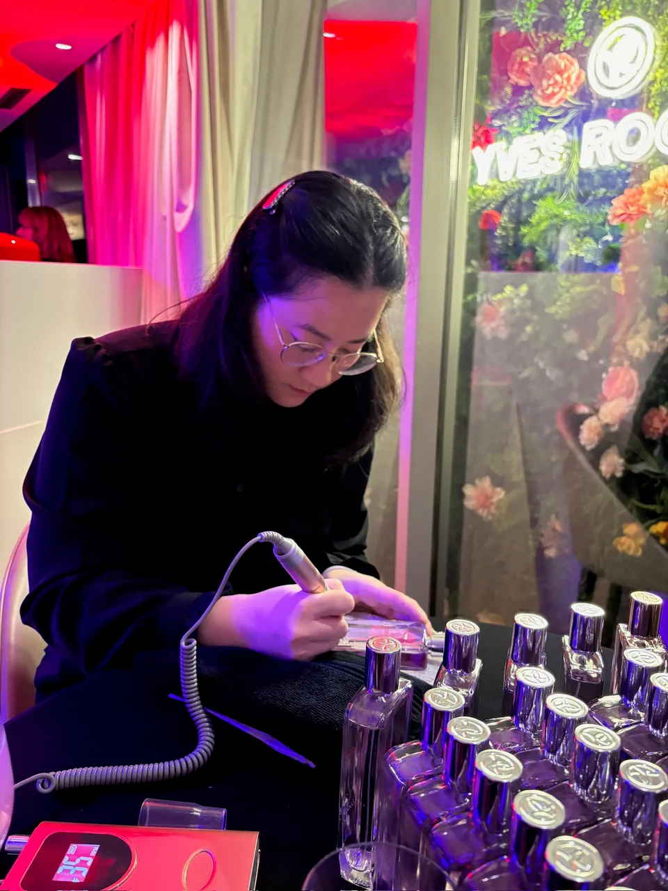 Cathy grave un flacon de parfum à la main lors d’un événement Yves Rocher