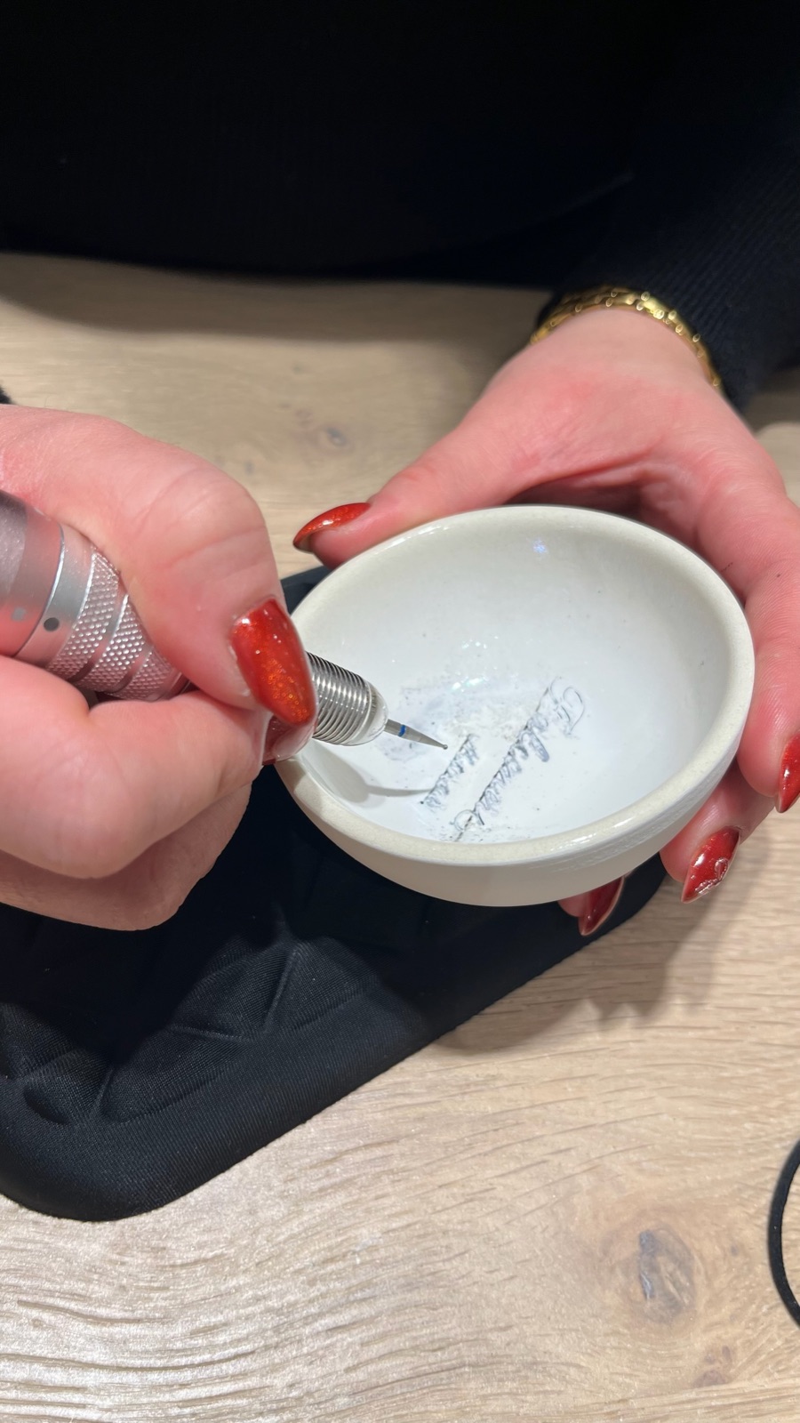 Gros plan des mains de Cathy gravant une pièce à la fraise diamantée