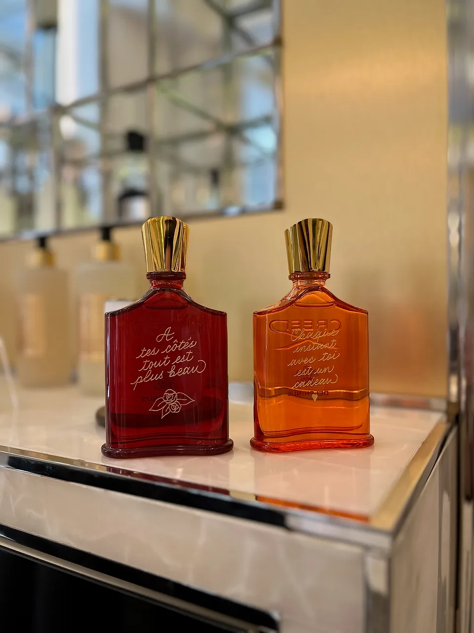 Two finished Creed perfume bottles with hand-engraved messages